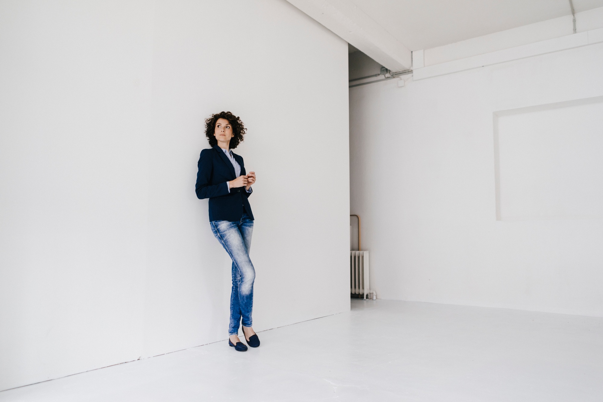 Businesswoman standing in loft , leaning against wall